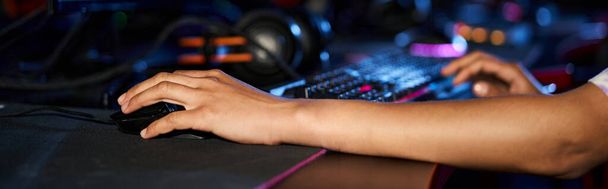 recortado tiro de la mujer usando el ratón de la computadora cerca del teclado iluminado mientras que juega juego, bandera - Foto, Imagen