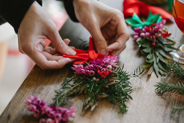 Uma pessoa que faz um buquê de flores para desejar o Natal a alguém - Foto, Imagem
