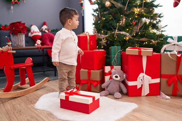Adorable garçon hispanique debout près de l'arbre de Noël à la maison - Photo, image