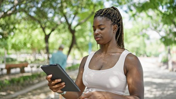 African american woman using touchpad at park - Foto, Imagem