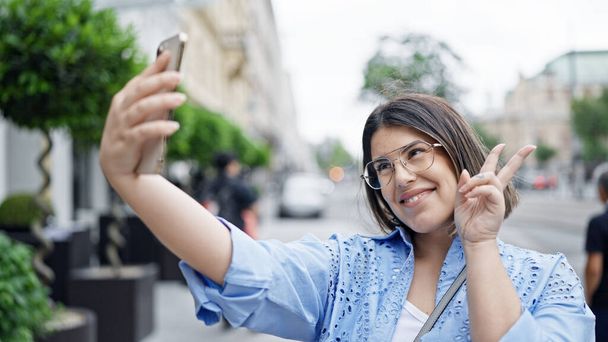 Fiatal gyönyörű spanyol nő szelfit készít okostelefonnal Bécs utcáin - Fotó, kép