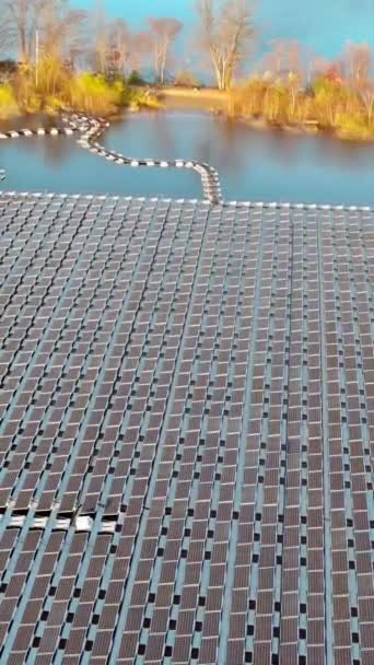 Vesilammikossa on kelluvia aurinkopaneeleita, jotka tuottavat sähköä auringonpaisteesta, kun se loistaa niihin - Materiaali, video