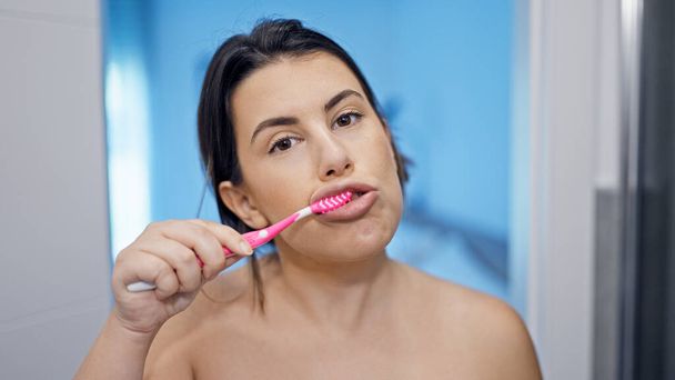 Joven hermosa mujer hispana cepillándose los dientes en el baño - Foto, imagen