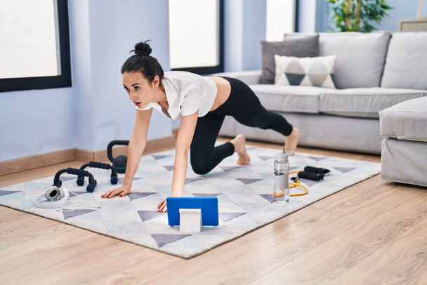 Genç beyaz kadın evde online bacak egzersizi yapıyor. - Fotoğraf, Görsel