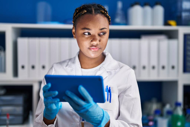 Afrikai amerikai nő tudós használó touchpad a laboratóriumban - Fotó, kép