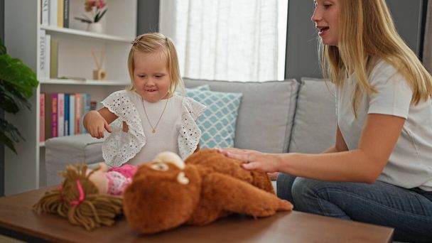 Felice madre caucasica e figlia piccola godendo comodamente e giocando con i giocattoli a casa, riposando sul divano - Foto, immagini