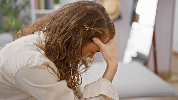 Stres mladá žena sedí sama na pohovce doma, ztělesňuje smutek a frustraci v jejím osobním konfliktu a deprese - Fotografie, Obrázek