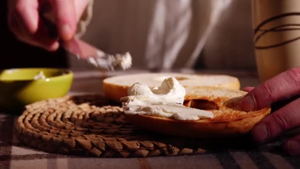 Dilimlenmiş ve krem peynirle kızartılmış bagel ekmeği sunarken orta boy zoom yavaş çekim seçici odak noktası - Video, Çekim