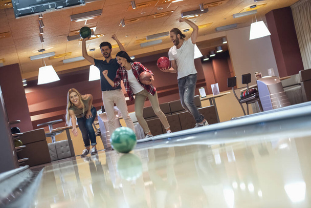 Happy young friends are having fun while playing bowling together - Photo, Image