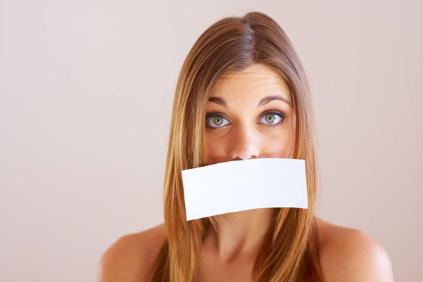Woman, mouth and sign for cover with mock up for silence in studio on white background. Portrait, female model and surprise in copy space for announcement, news or secret with placard, sign or poster. - Photo, Image
