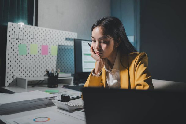 Asijky žena je ve stresu při práci na notebooku, unavený asijské podnikatelky s bolestí hlavy v kanceláři, pocit nevolnosti v práci, stresované dospělé podnikatelky vypadající ustaraně. - Fotografie, Obrázek