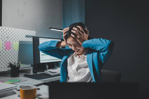 Азіатська жінка стресує під час роботи на ноутбуці, втомилася азіатська бізнес-леді від головного болю в офісі, відчуває себе погано на роботі, стрес зрілої бізнес-леді виглядає стурбованою. - Фото, зображення