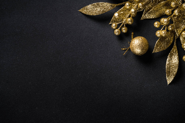 Christmas gold decorations on black. Flat lay image with copy space. - Photo, Image