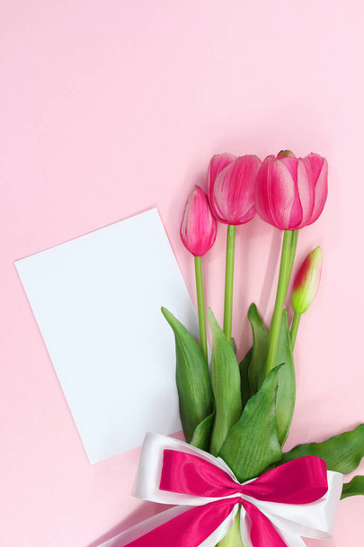 Buquê de presente de tulipas rosa com arco e papel. Dia Internacional da Mulher e da Mãe, aniversário, Dia dos Namorados, feriado. Espaço de cópia - Foto, Imagem