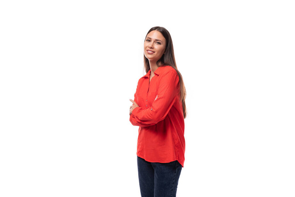 beautiful young business woman with black hair dressed in a red shirt holds her hands near her body on a white background with copy space. - Photo, Image