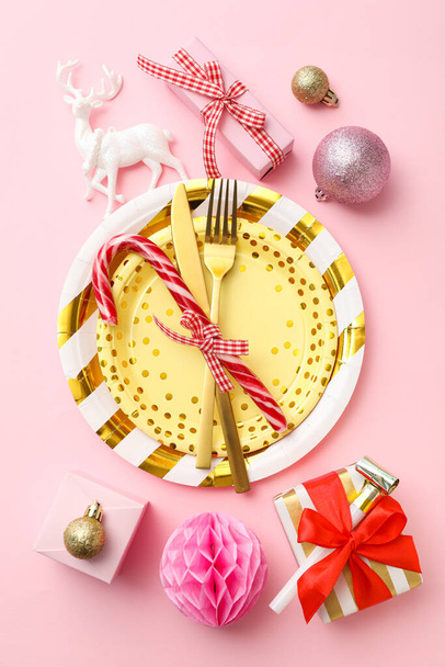 Pratos, talheres, caixas de presente e decorações sobre fundo rosa, vista superior - Foto, Imagem