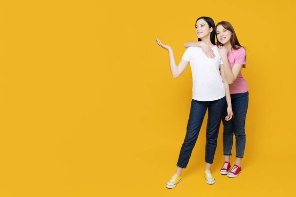 Дві сестри позують на жовтому тлі - Фото, зображення