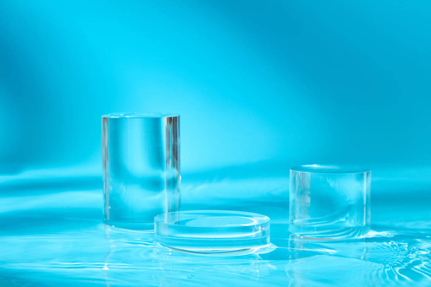 Tre podi trasparenti in forma rotonda e cilindrica visualizzati sull'acqua. Spazio vuoto per mostrare i vostri beni o prodotti di bellezza - Foto, immagini