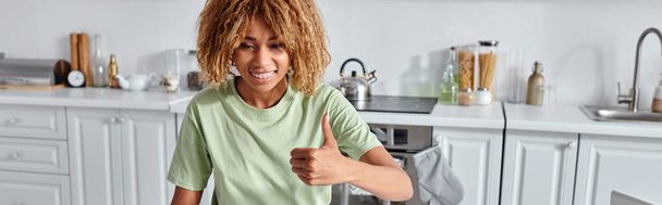šťastná africká americká žena ukazující palec nahoru během videohovoru na notebooku, jako gesto banner - Fotografie, Obrázek
