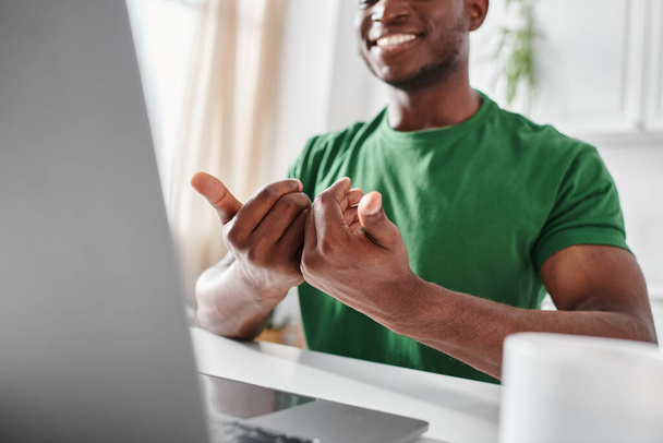 обрезанный счастливый глухонемой африканский мужчина, использующий язык жестов для общения во время онлайн-встречи - Фото, изображение