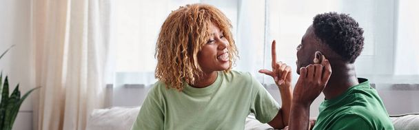 Couple afro-américain communiquant avec la langue des signes à la maison, homme noir dans la bannière de prothèse auditive - Photo, image