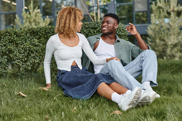 happy african american couple using sign language for communication while sitting on grass - Fotografie, Obrázek
