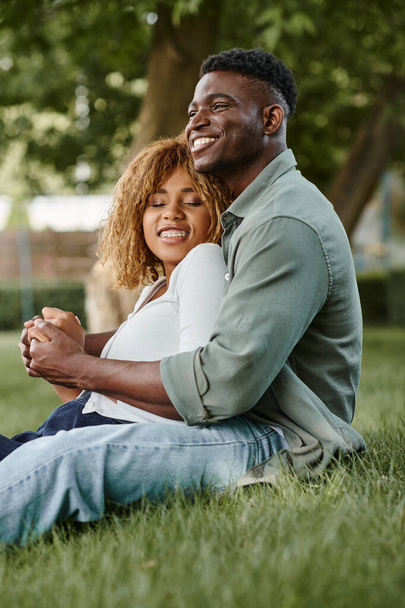 heureux couple afro-américain passer du temps de qualité avec l'autre dans le parc, se tenant la main - Photo, image