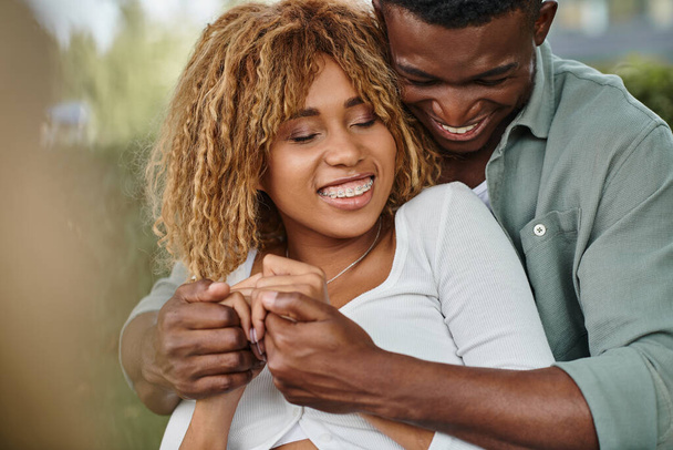 笑顔のアフリカ系アメリカ人のカップルは,公園でお互いに質の高い時間を過ごし,手を握っています - 写真・画像