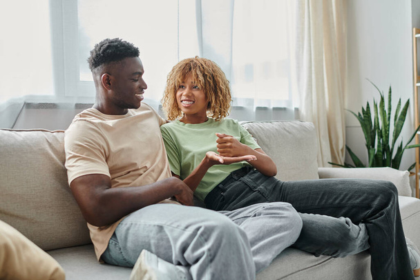acogedora conversación de pareja afroamericana feliz usando lenguaje de señas para la comunicación en casa - Foto, Imagen
