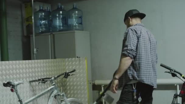 Kézi lehajtható lövés a javítóműhely munkavállaló alkalmazó hab zsírtalanító tömlő a kerékpár mosás előtt a garázsban - Felvétel, videó