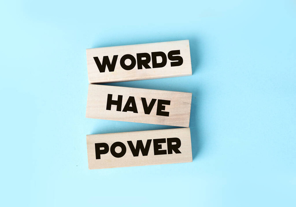 Kelimelerin gücü mavi arka planda duran tahta bloklarda bulunur. Reklam yazarlığı halkla ilişkiler kavramı - Fotoğraf, Görsel