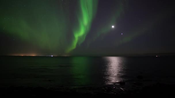 Aurora borealis reflecting in ocean in front of Moon and Venus - Footage, Video