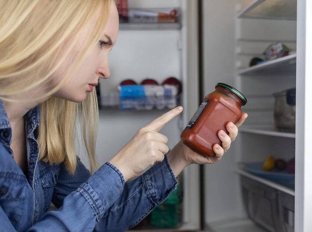 Woman reads instructions for food products at home. Checking labels on goods. Study of product compositions. Search Internet for descriptions of product gradients. Useful or harmful. Nutritionology - Photo, Image