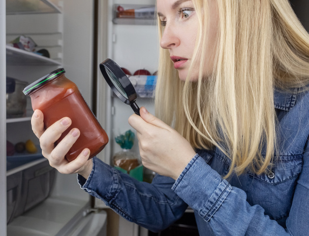 Woman reads instructions for food products at home. Checking labels on goods. Study of product compositions. Search Internet for descriptions of product gradients. Useful or harmful. Nutritionology - Photo, Image