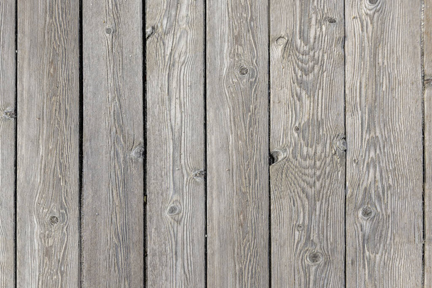 Egy szürke, lakkozatlan fa deszka padló homokszemekkel a felszínen. Vektor fa textúra háttér - Fotó, kép