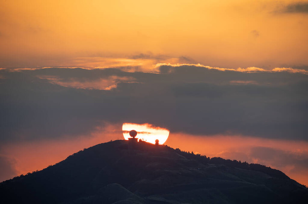 Gros plan spectaculaire sur le processus du coucher du soleil. Ciel orange flamboyant. Au premier plan se trouve la station radar météorologique de Wufenshan. Ruifang, Taiwan. - Photo, image
