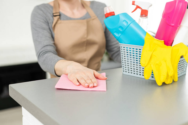 家事をする若い女性。掃除道具を持ってる女。ゴム保護黄色の手袋を身に着けている女性は、ラグとスプレーボトル洗剤を保持。春の掃除には遅すぎることはない. - 写真・画像