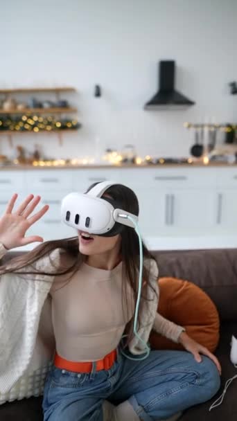 Nello spirito della stagione, una giovane donna affascinante esamina il suo regalo di Natale - un auricolare realtà virtuale. Filmati 4k di alta qualità - Filmati, video
