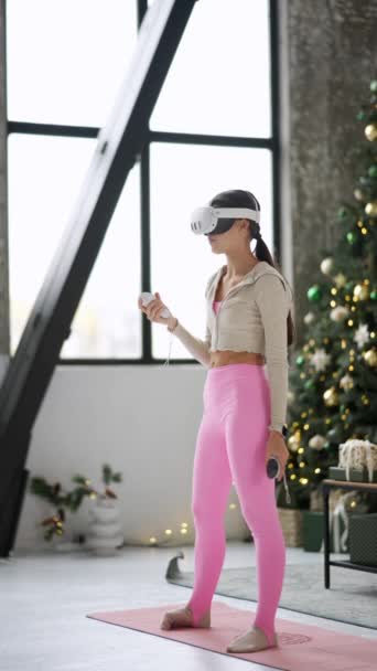 Вдома під час святкового сезону активна молода жінка займається вправами з використанням гарнітури віртуальної реальності. Високоякісні 4k кадри - Кадри, відео