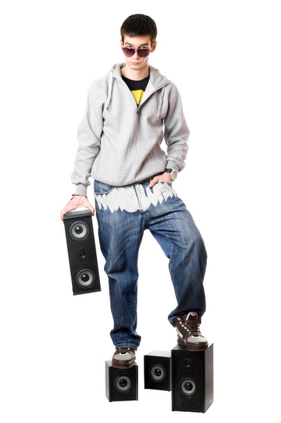 Junger Mann mit Sonnenbrille steht auf den Lautsprechern - Foto, Bild