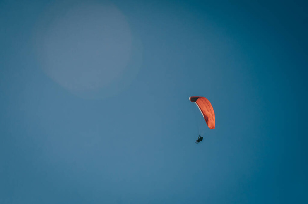 Parapente que se eleva a través de las alturas, se pueden ver las nubes y el cielo azul - Foto, imagen