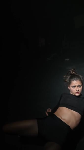 В темной студии молодая девушка исполняет современный танец. Высококачественные 4k кадры - Кадры, видео