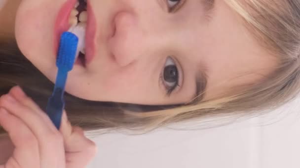 Linda menina bonito escovar os dentes em casa. Cuidados dentários para crianças. Close-up. Vídeo vertical. - Filmagem, Vídeo