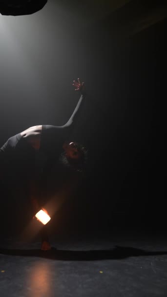 Великолепная женщина демонстрирует хореографические движения современного танца, держа свет. Высококачественные 4k кадры - Кадры, видео