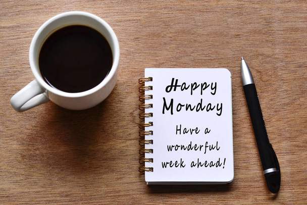 Щасливий понеділок з мотиваційною цитатою на блокноті з чашкою кави та ручкою на дерев'яному столі. - Фото, зображення