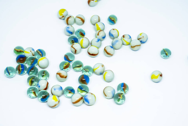 close-up de coleção de brinquedos de mármores de vidro com interior colorido isolado em fundo branco - Foto, Imagem