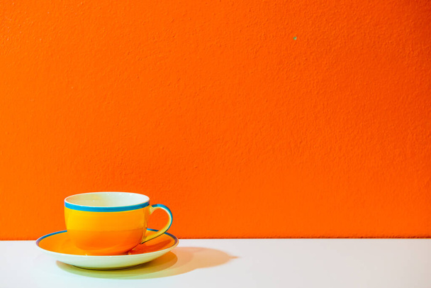 Gelbe Kaffeetasse mit Orangenwand, Thailand. - Foto, Bild