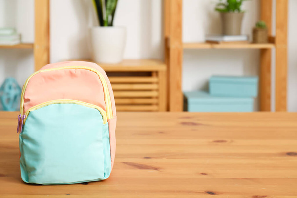 Стильний шкільний рюкзак на дерев'яному столі у вітальні - Фото, зображення