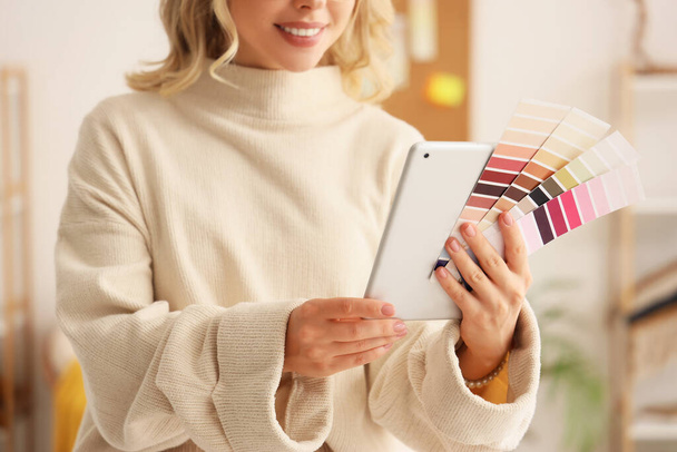 Diseñadora de interiores femenina con tablet y paletas de colores en la oficina, primer plano - Foto, imagen