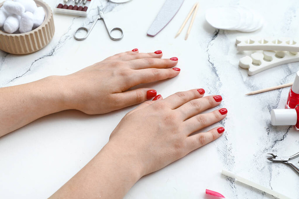 Ženské ruce se stylovými červenými nehty a manikúrou zařízení na bílém pozadí grunge - Fotografie, Obrázek